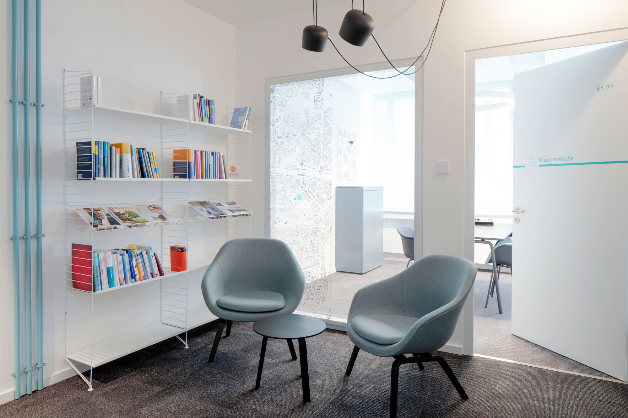 Sitzecke mit zwei Sesseln und Bücherregal – Smartwork: neue Bürowelten bei den Stadtwerken München
