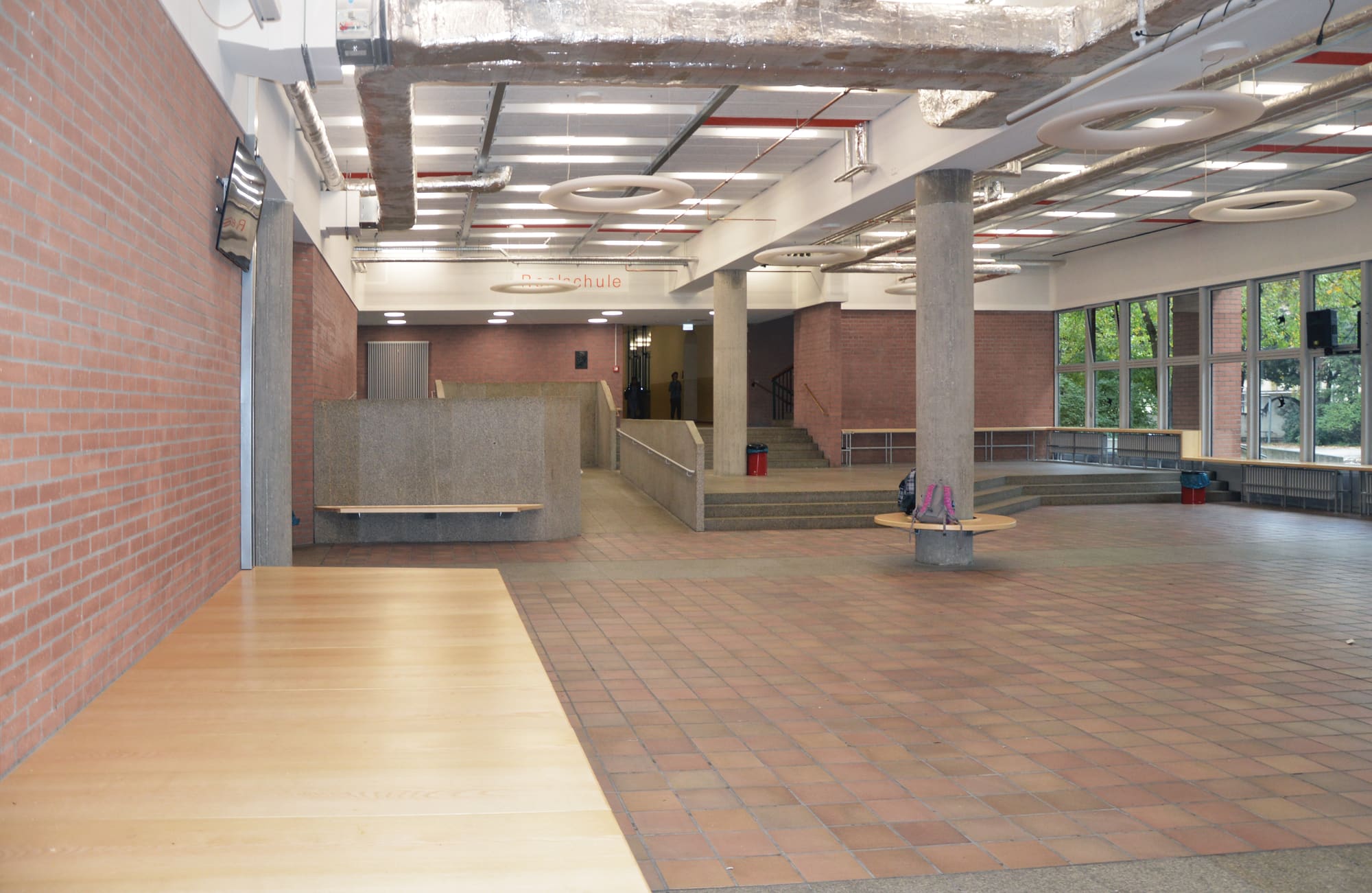 Blick durch die sanierte Halle entlang der Fenster – Akustische Sanierung der Pausenhalle der Carl-von-Linde-Realschule