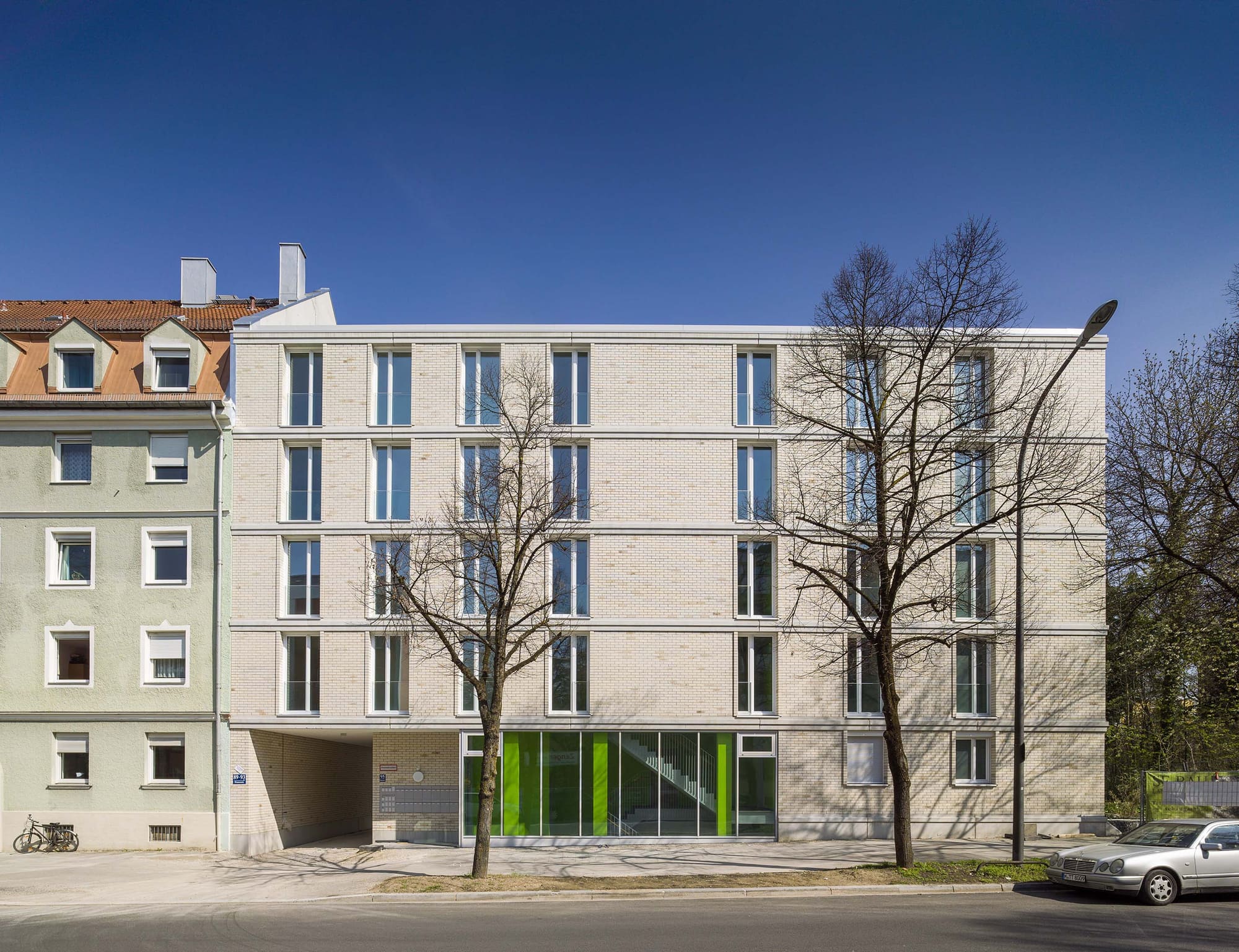 Straßenansicht des Neubaus neben dem Bestand – Hansastraße 89: Neubau von 73 Wohnungen in München