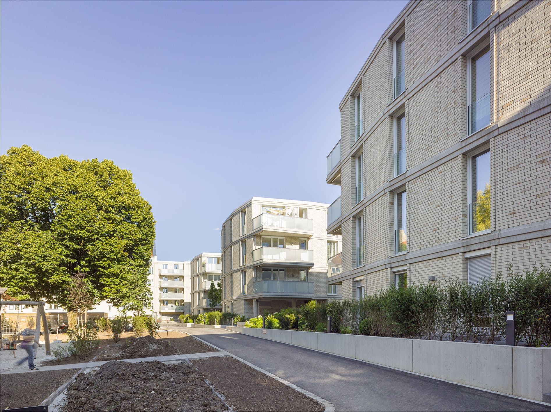 Weg entlang der Wohngebäude – Hansastraße 89: Neubau von 73 Wohnungen in München