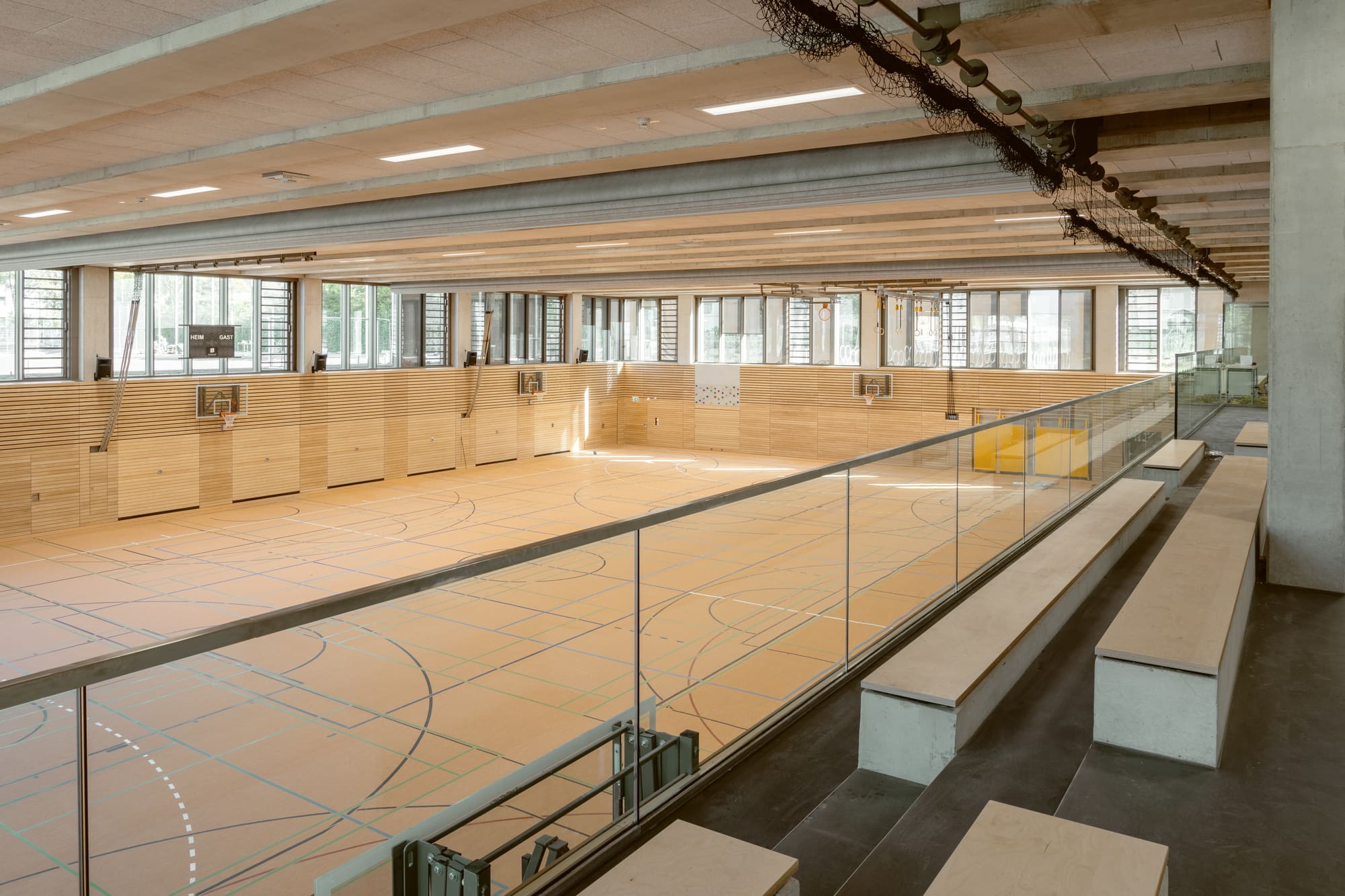 Turnhalle mit Spielfeld und hölzernem Ausbau – Grundschule Haar: Erweiterung, Turnhalle und Tiefgarage