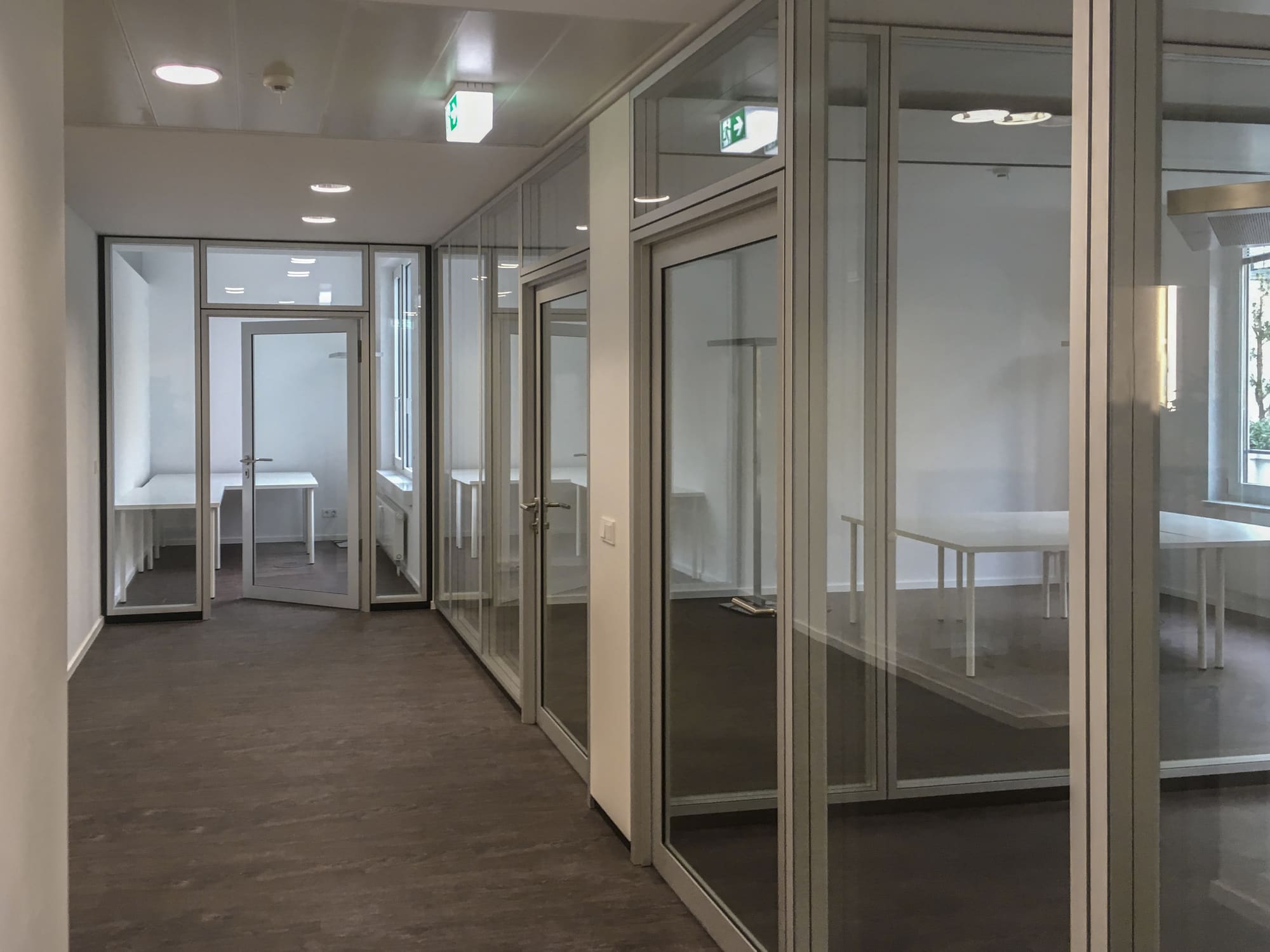 Flur mit verglasten Unterrichtsräumen – Von Büroflächen zur Sprachschule in München