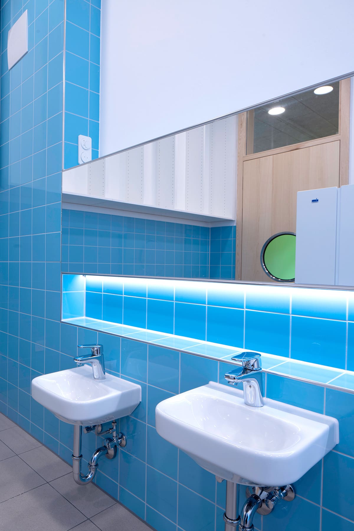 Kinderwaschbecken vor blauen Wandfliesen – Innenausbau eines Kindergartens in Germering